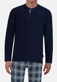 Navy long-sleeve shirt with a henley neckline and three buttons, paired with blue plaid pajama pants featuring light and dark squares.