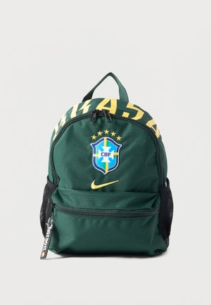Sac à dos vert foncé avec l’écusson de football du Brésil, le logo Nike jaune, tirette de fermeture éclair « JUST DO IT. » et poches latérales en mesh.