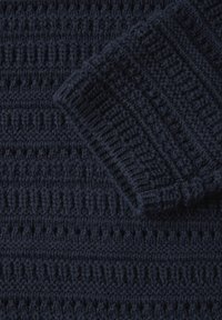 Stickad tröja i mörk marinblå garn med texturerade mönster av ribbning och öppna maskor, med rundad krage och ärmslut.