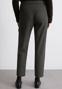 Pantaloni grigi a scacchi con vita elastica, taglio slim, tasca cargo laterale e tasca posteriore. Orlo arrotolato alle caviglie.