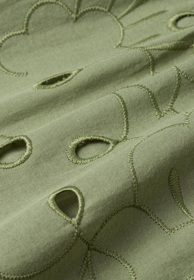 Tăvălug verde măsliniu cu broderie cu forme florale și detalii tăiate. Textura pare moale cu o finisare netedă.