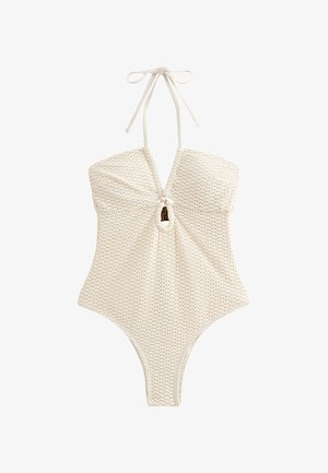 Bañador de una pieza blanco con tela texturizada, tirantes tipo halter y detalle de ojo de cerradura en el frente. Diseño elegante con piernas de corte alto.