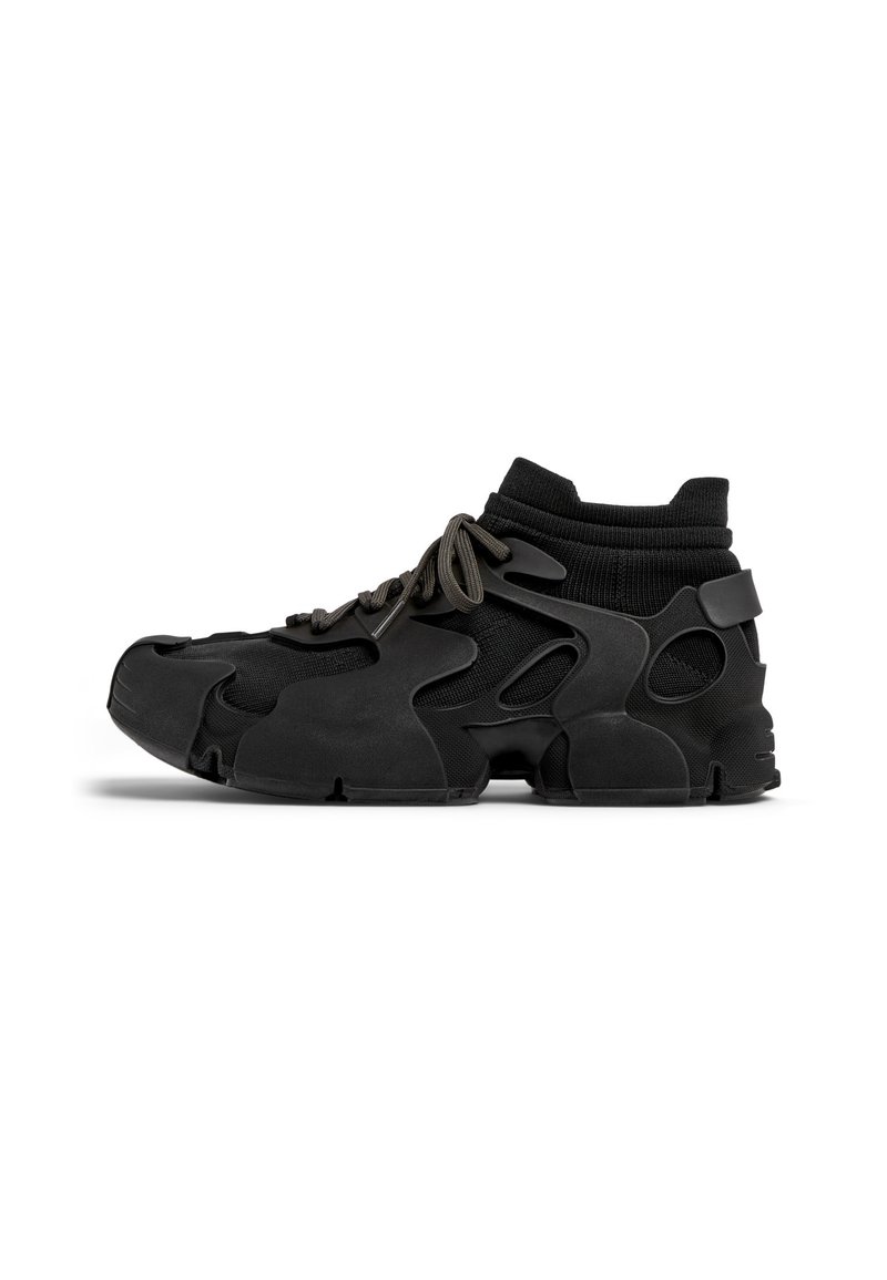 Sort sneakers med et støbt design med udskårne sektioner, tekstureret stofkrave og tykke snørebånd, der giver et moderne, atletisk udseende.