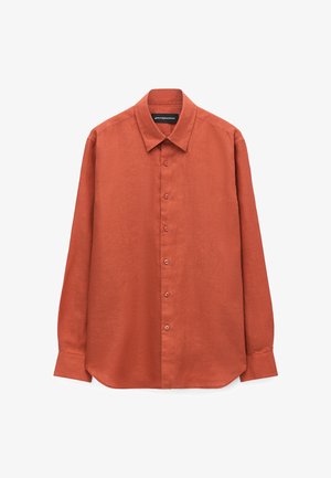 Rust-colored long-sleeve button-up shirt with a classic collar, buttoned cuffs, and a slightly curved hem, displayed on a white background.