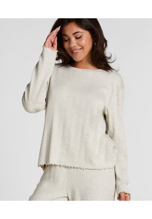 Lichtgrijze, geribde pullover met lange mouwen en een ronde halslijn. Heeft gegolfde manchetten en zoom voor extra textuur.