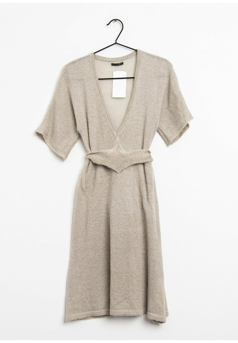 Beige stickad klänning med djup V-ringning, korta ärmar och figursydd midja. Har ett matchande bälte och en texturerad tyg. Tagg fäst.