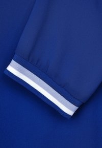 Blått tyg med en jämn struktur, prytt med en manschett med ett vit- och gråstrimmigt band. Designen är enkel och praktisk.