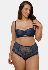 Ensemble de lingerie en dentelle bleu nuit comprenant un soutien-gorge balconnet à motifs floraux et des culottes taille haute en mesh avec des accents en dentelle.