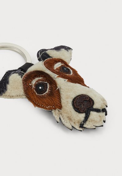Porte-clés en forme de chien en tissu doux avec des couleurs marron et blanc, présentant un visage brodé avec des accents noirs et un anneau en métal.