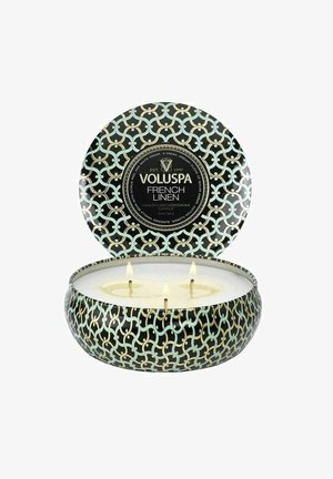 Voluspa French Linen tre-væge lys i dekorativ sort, gylden og grøn mønstret blikdåse med låg, der er proppet op bagved.