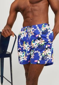 Zwemshorts in het blauw met een tropisch patroon van toekans en bloemen, gemaakt van lichte stof met een elastische tailleband en een trekkoord.