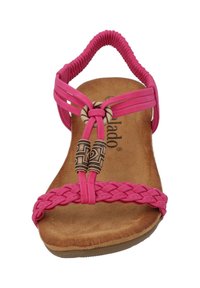 Sandale rose avec des brides tressées, des accents en bois décoratifs et une semelle intérieure marron rembourrée. Elle dispose d'une semelle épaisse et flexible pour le confort.
