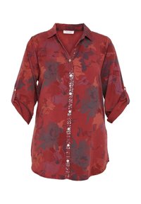 Blouse rouge à fleurs à manches longues avec un col, fermeture boutonnée ornée de sequins sur le devant, et manches retroussées avec pattes de boutonnage.