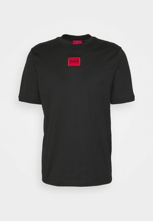 Black short-sleeve t-shirt made of smooth fabric, featuring a red rectangular logo patch with "HUGO" centered on the chest.