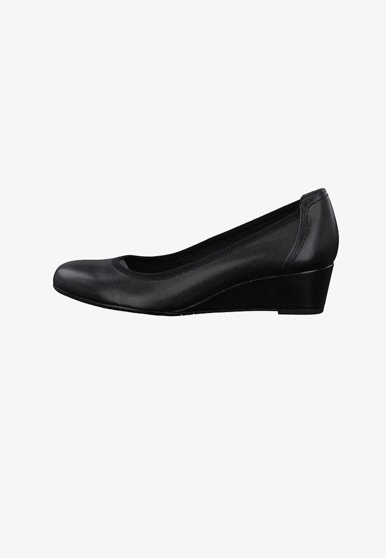 Chaussure en cuir noir à talon compensé avec un bout rond et un petit talon. Texture lisse et design minimaliste avec des coutures latérales et une doublure douce.