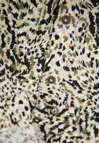 Košilové tričko na krách s krémovým pozadím a abstraktním vzorem v černé, zelené a broskvové barvě. Obsahuje tmavé knoflíky a strukturovanou tkaninu.