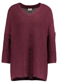 Vinröd oversized tröja i texturerad stickning med V-ringning och vida ärmar, med ett öppet vävmönster och ribbade detaljer.