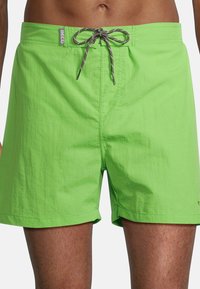 Shorts de bain vert vif en matériau léger, avec une fermeture à cordon de serrage et des accents gris, ainsi qu'une poche avant.