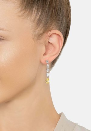 Dangling earrings with three clear gemstones in marquise and pear shapes, and a yellow pear-shaped stone at the bottom. Silver metals used.