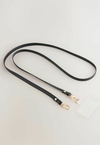 Correa de cuero negra con una textura suave, que presenta clips de metal en tono dorado y una pequeña etiqueta desmontable. Diseño elegante y minimalista.