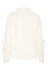 Blusa bianca di cotone con yoke posteriore, colletto alla francese e maniche lunghe con chiusure a fiocco sui polsini. Texture liscia.