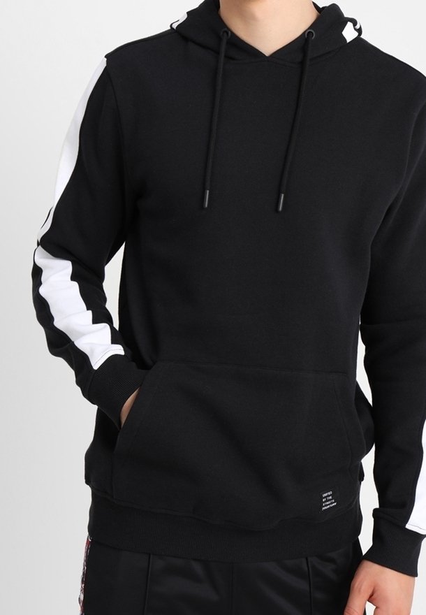 Svart hoodie i mjukt tyg med en framficka, justerbara snoddar och vita detaljer på ärmarna. Ribbad mudd och nederkant.