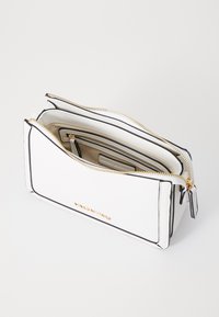 White leather bag with black trim and gold hardware, featuring two zippered compartments and a textured surface. Logo embossed on front.