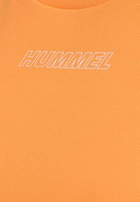 Orange sports top lavet af tekstureret stof, med rund halsudskæring og hvid "HUMMEL" logo trykt på forsiden.