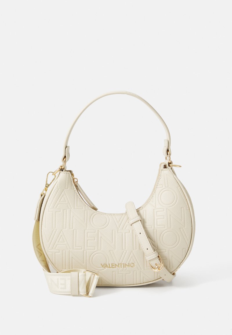 Kréma krāsas pusmēness formas Valentino rokassoma ar iegrieztu logo rakstu, zelta detaļām, īsu rokturi un noņemamu regulējamu plecu siksnu.