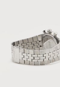 Ατσάλινο ρολόι χειρός με μεταλλικό μπρασελέ με συνδέσμους, ορατό κούμπωμα χαραγμένο με τη λέξη "BOSS" και κουμπιά χρονογράφου στην κάσα του ρολογιού.