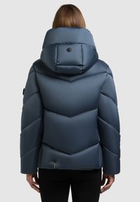 Tumesinist värvi sulejope kõrge kraega, tikitud chevron-mustriga ja nupukujundusega tagaküljel. Pehme ja sile tekstuur.