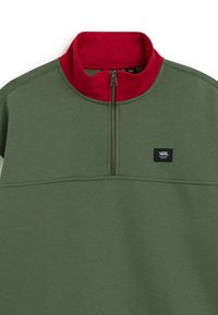 Pull en polaire vert zippé avec un col haut rouge, fabriqué à partir d'un tissu doux. Présente une couture horizontale et un petit écusson logo sur le devant.