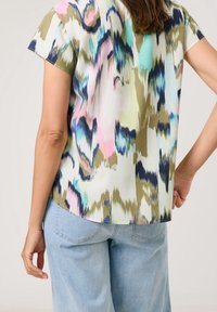 T-shirt à manches courtes avec un motif abstrait multicolore dans des teintes pastel, fabriqué en tissu léger avec une coupe décontractée.