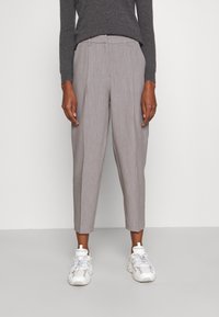 Grå skræddersyede bukser med stribet mønster, tilspidsede ben og forreste læg, kombineret med hvide atletiksneakers. Tekstureret stof.