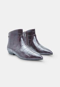 Burgundy ankle boots in a crocodile pattern, made of glossy leather. Features pointed toes and side zippers for closure. Low heel design.