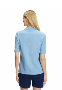 Polo azzurro chiaro a maniche corte con colletto, realizzato in cotone liscio. Design aderente senza motivi o dettagli visibili.