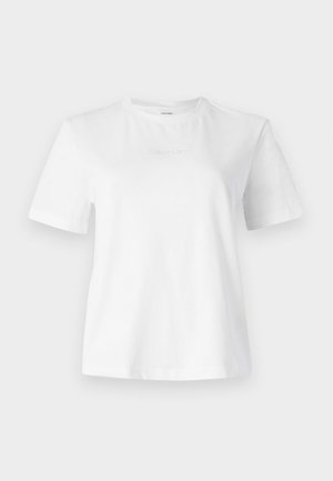 Balta medvilnė marškinėliai trumpomis rankovėmis, apvaliu iškirpimu ir subtiliu iškilniu Calvin Klein logotipu priekyje. Lygi tekstūra, klasikinis pjūvis.