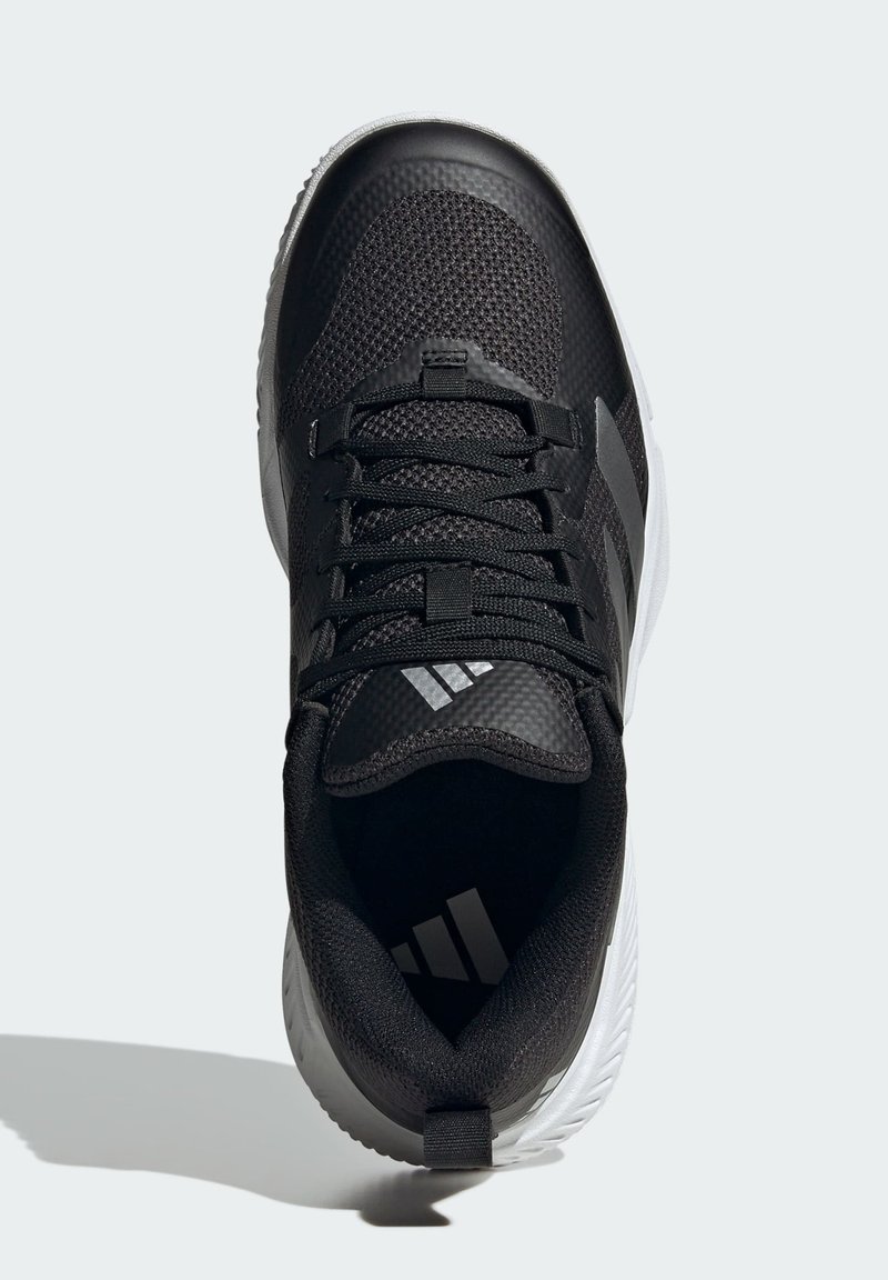 Baskets noires avec une tige en mesh texturé, des lacets et trois rayures blanches. Talon renforcé et semelle en caoutchouc avec des accents blancs.
