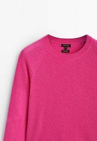 Różowy sweter z kaszmiru o okrągłym dekolcie, z prążkowanymi mankietami i miękkim, teksturowanym wykończeniem. Posiada rękawy raglanowe oraz widoczne metki marki.