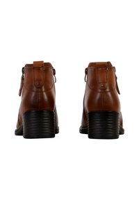 Bruine leren enkellaarzen met een ronde neus, ritsluiting en ribbelachtige zwarte hak, met een gladde textuur en minimale hardware accenten.