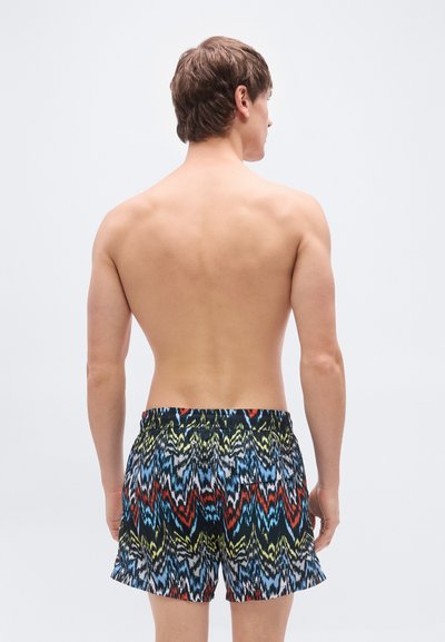 Ανδρικό μαγιό σορτς με πολύχρωμο ζικ-ζακ μοτίβο σε κόκκινο, μπλε, κίτρινο και μαύρο. Ελαστική μέση με πίσω τσέπη.