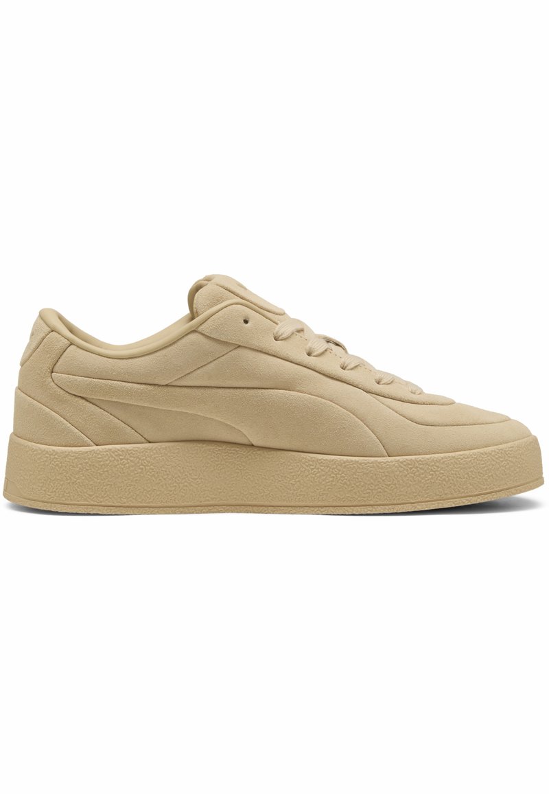 Zapatillas de ante beige con una textura suave, diseño de perfil bajo, puntera redonda y suela de goma texturizada. Presenta un sutil detalle de costura.