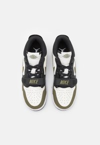 Bílé a olivově zelené tenisky s texturovaným koženým svrškem, perforovanou špicí, černými akcenty a páskem s logem Nike.