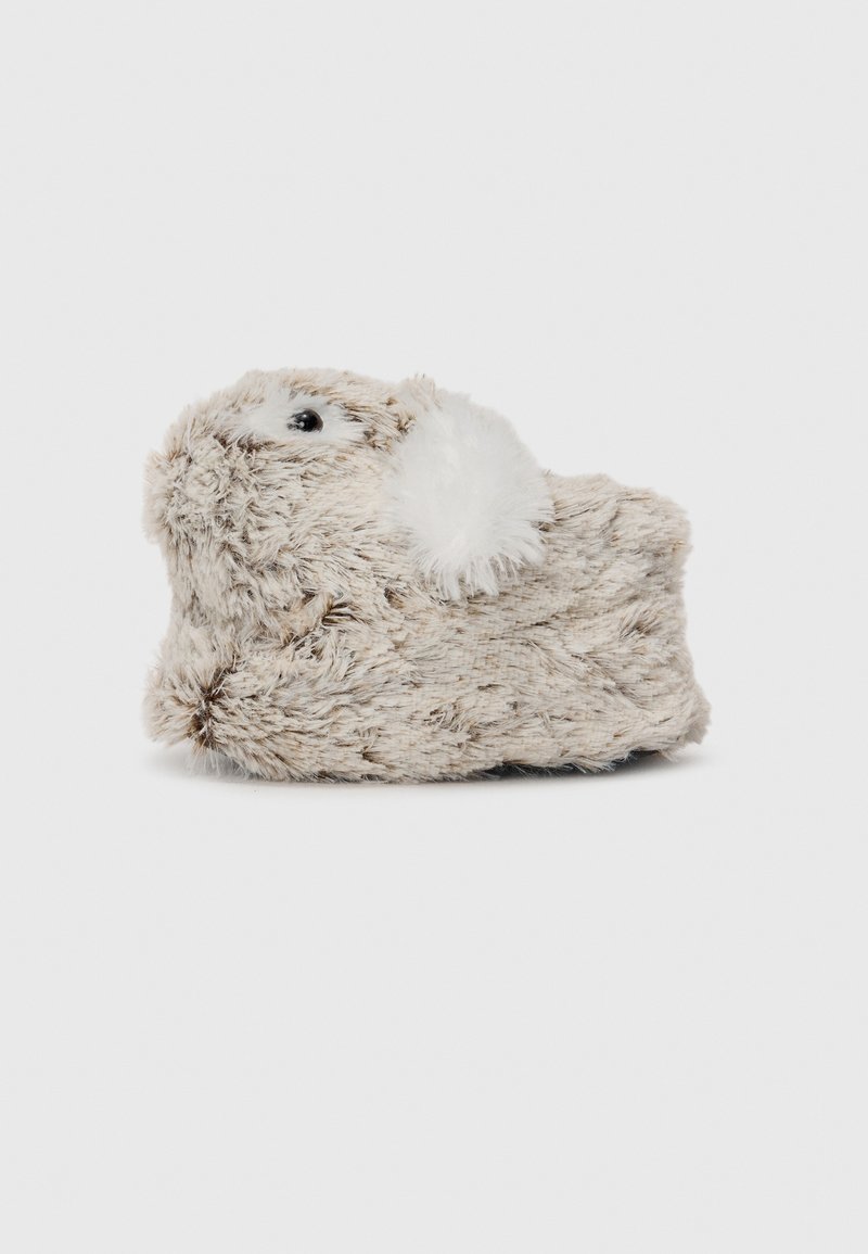 Chausson doux et pelucheux en forme d'un petit animal avec une oreille blanche et duveteuse et un œil bouton noir sur un fond clair.
