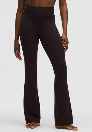 Schwarze schmal geschnittene Yogahosen mit hohen Bündchen, hergestellt aus dehnbarem Material, das eine glatte Textur und eine figurbetonte Silhouette bietet.