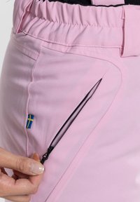 Rosa tygshorts med resårmidja, med en sidokort ficka med dragkedja och en liten svensk flagga sydd på sidan.