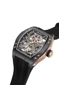 Samodejna ura s črnim gumijastim trakom, ohišjem iz nerjavečega jekla, prozornim zaslonom, poudarki v rožnato zlati barvi, zapletenim dizajnom zobnikov in izrazitim kronanjem.