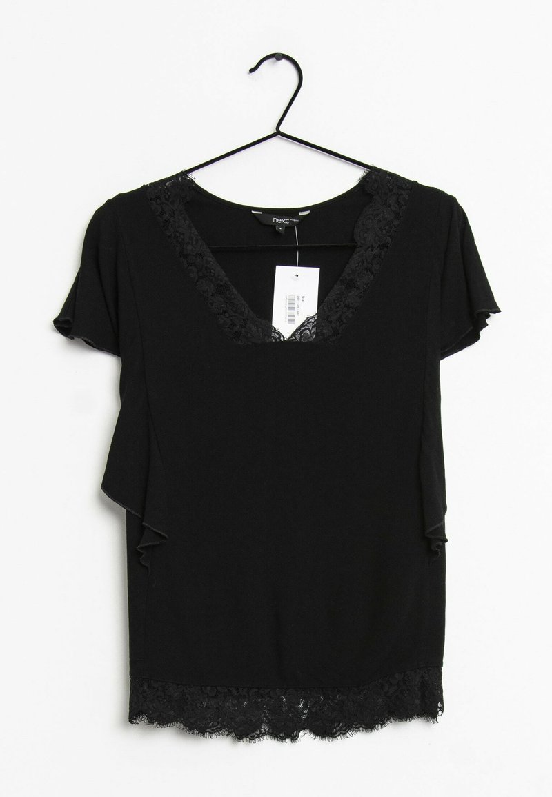 Haut noir à manches courtes avec un décolleté en V, bordé de dentelle autour du col et de l'ourlet, offrant une coupe ample et un tissu doux. Étiquette attachée.