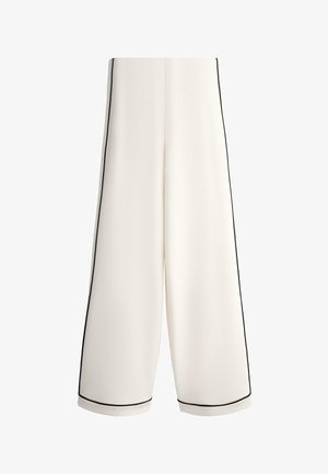 Biele nohavice s širokými nohavicami s čiernym lemovaním pozdĺž strán a okrajov, s vysokým pásom a čistým, minimalistickým dizajnom.