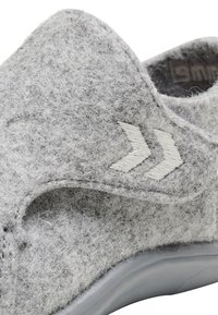 Grå slip-on sko med rund tå, med en utskärning design och vita logotypdetaljer. Flekibel grå sula med texturerad yta.